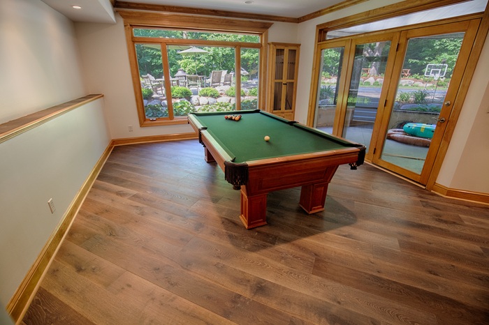 Sanding and finishing premium engineered walnut hardwood flooring on a concrete slab foundation